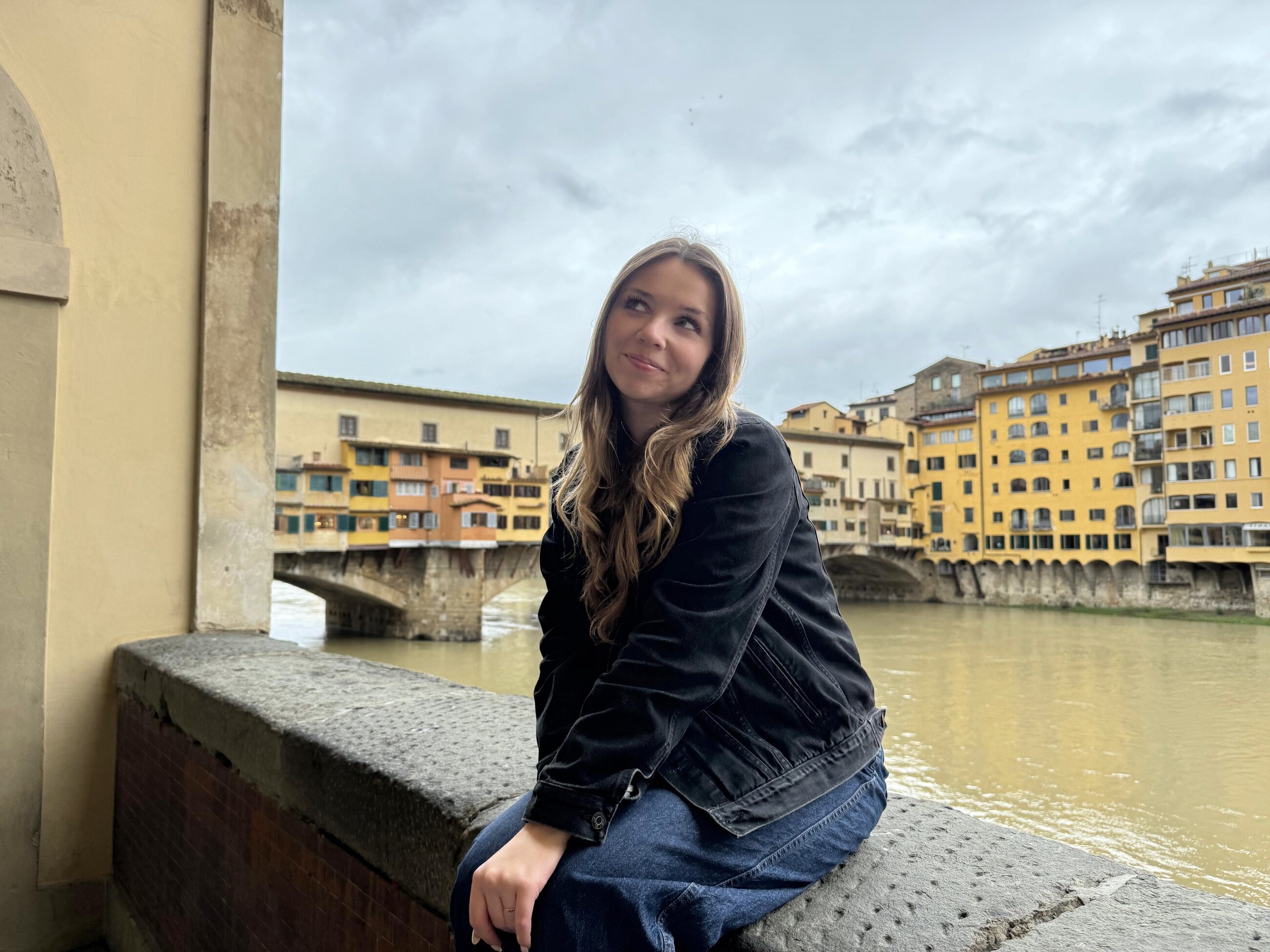Me sitting near the canal in Florence, Italy