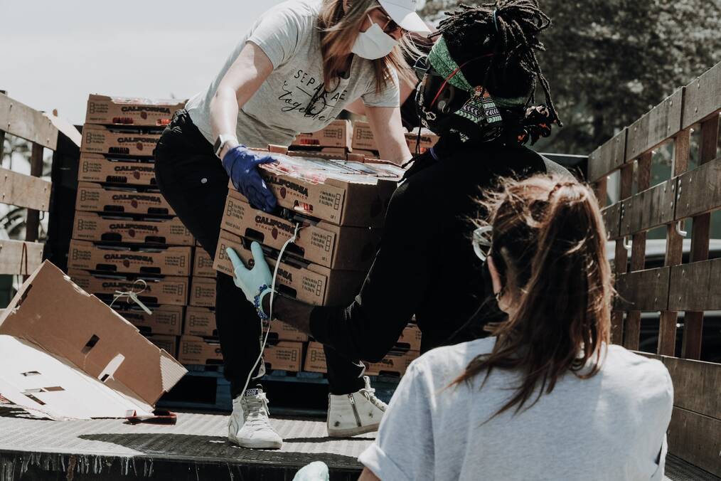 People loading boxes off a truck.