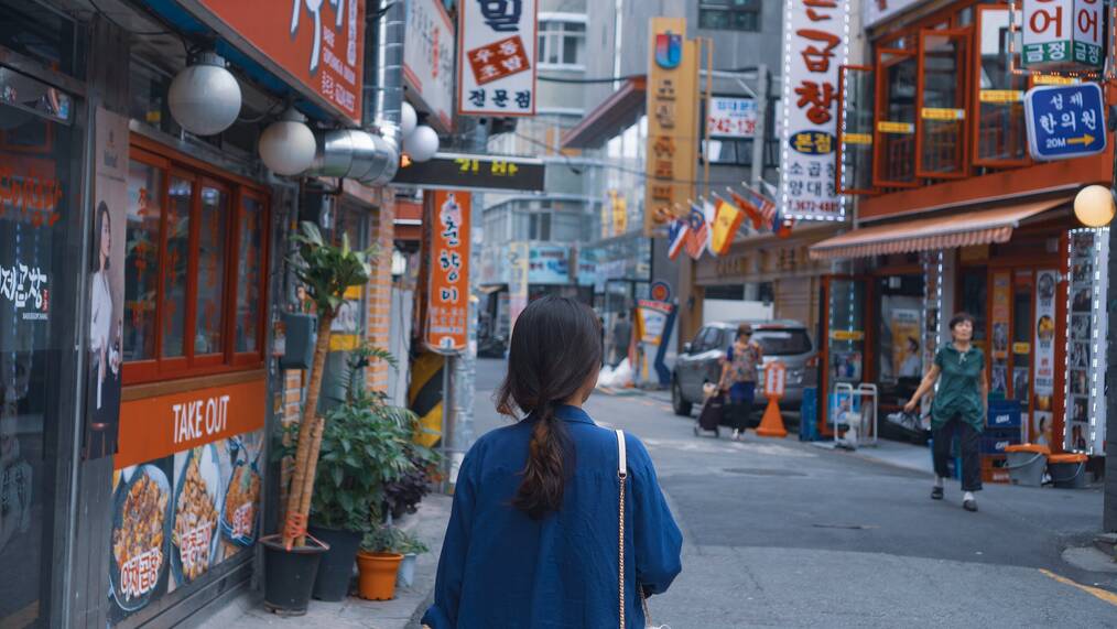 Woman walking on street in Seoul.