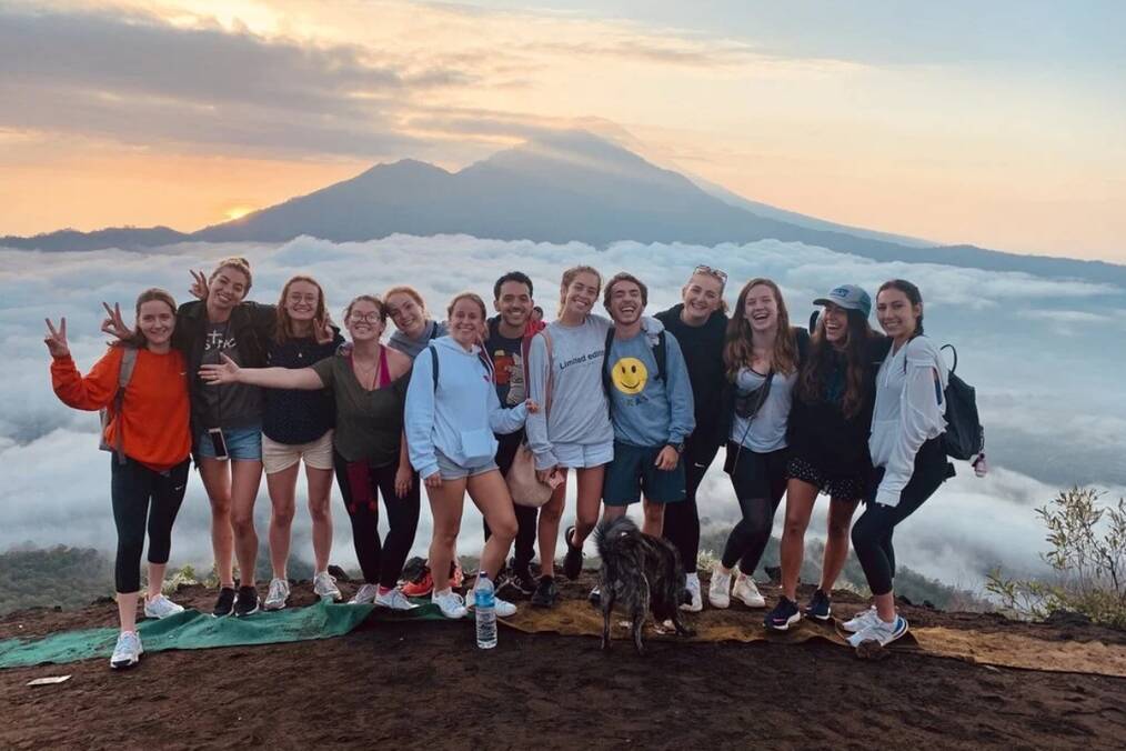 A group of travelers smiling on a mountain