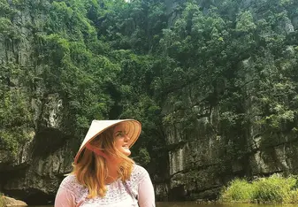 Girl on boat with Vietnamese hat