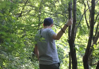 Cody descending down through a lush forest on the side of the Great Wall at Mutianyu
