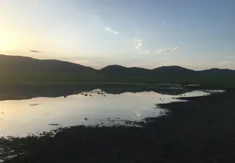 Sunset over mountains with lake in foreground