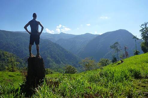 person standing on top of a tall rock