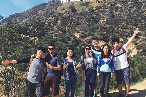 People posing in front of Hollywood sign