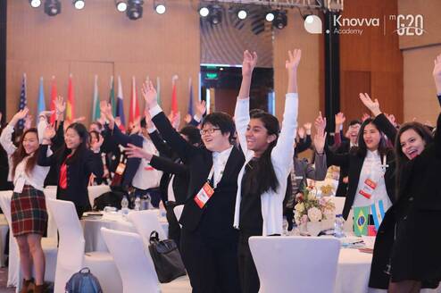 Students wave at aModel G20 Youth Leadership Summit