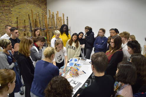 Group of young students gathered around a painting