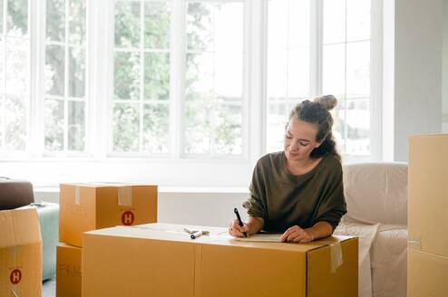 Person writing on moving boxes