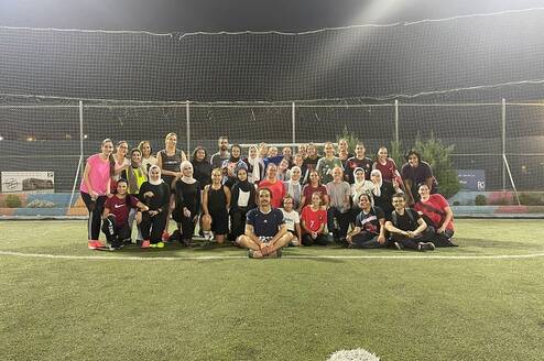 Students and local jiran posing for a photo after playing a pickup game of soccer