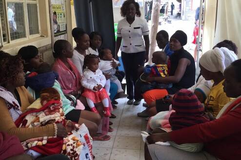 A nurse doing reproductive health education to young ladies within a community setup