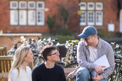 students talk on a bench