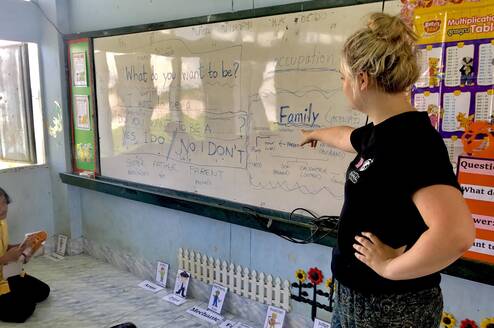 Teacher pointing to white board