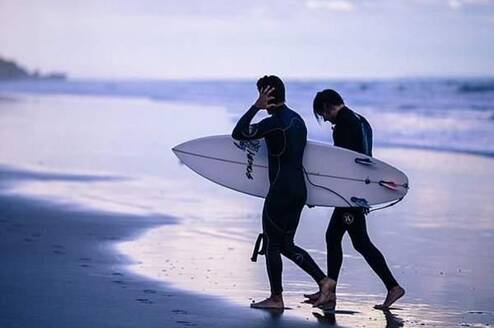 two surfers walking