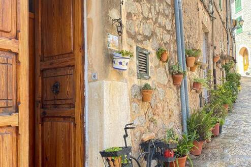 A quaint alleyway featuring a vintage bicycle leaning against a weathered door, capturing the essence of Spain and RVF International’s teach abroad adventure.