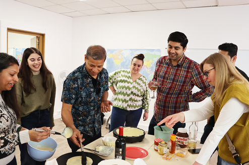 Students participating in a crêpe-making workshop as part of a French language immersion program in Paris.