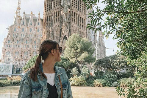A girl looks at the Sagrada Familia cathedral