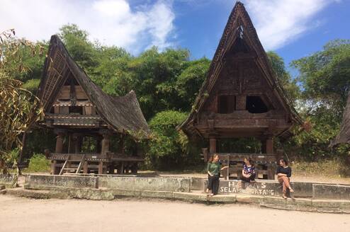 AFS Students sitting in front of old traditional houses in Indonesia