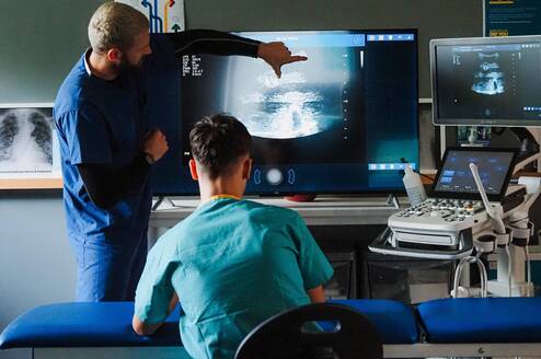 Doctor teaching ultrasound imaging to students during a hands-on clinical skills summer programme in Liverpool