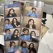 A close-up shot of two photo booth strips being held by someone with long, manicured nails. Each strip contains multiple small photos of two friends making various playful and expressive poses. The background of the photo booth appears to be wooden. One friend is wearing a denim jacket and glasses, while the other has long dark hair and is wearing a black top. The setting seems casual and fun, with the friends enjoying themselves in the photo booth. The strips are labeled "Mono mansion" at the bottom. In th