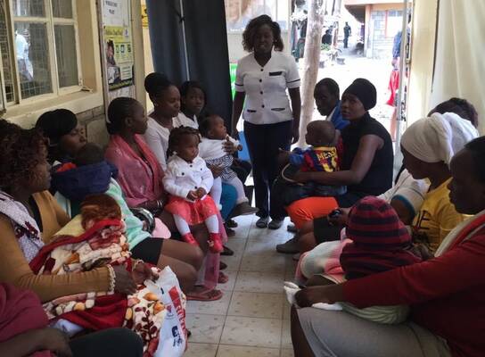 A nurse doing reproductive health education to young ladies within a community setup