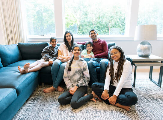 Au pair sitting with host family in the living room
