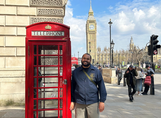 Man standing beside a British red telephone box