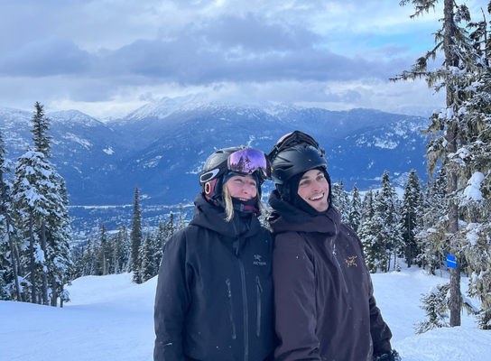 Two people on a snowy mountain with ski gear on