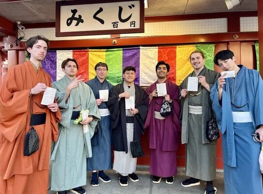Group of students in kimonos in front of a colorful wall