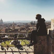 man sitting looking out over town 