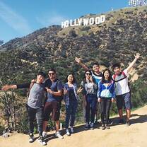 People posing in front of Hollywood sign