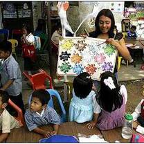 The lady teaching the kids different colors