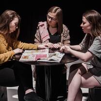 Three girls talking while looking at the magazine