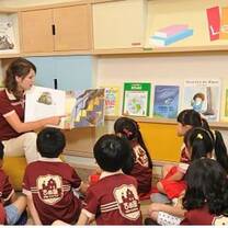 The girl read a story and the kids are listening