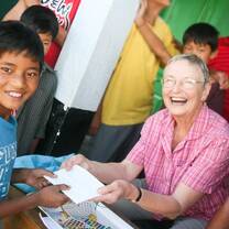 An old lady giving a paper to the young boy