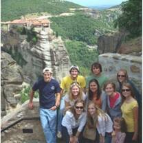 group of men and women taking picture on top of a mountain