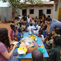 group of kids and volunteers around a table eating together
