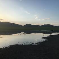 Sunset over mountains with lake in foreground