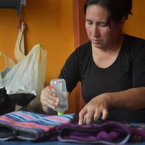 An artisan using fabric glue on a garment