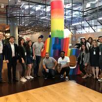 group of participants in building with bright colored pole behind