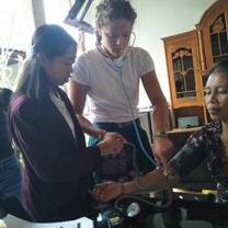 This is a picture of me taking the heart rate of a local woman in her home.