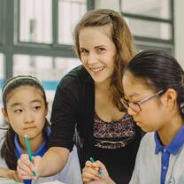 Female teacher, smiling, and helping students