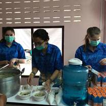 3 Team members are serving soup from a stand in a hospital.