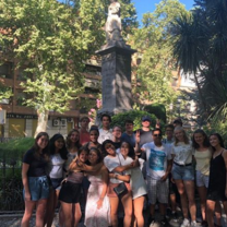 The whole group together on the last day, next to a statue near the central square.