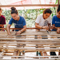 Pacific Discovery students weaving wood for building in Cambodia