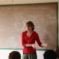 Pacific Discovery student standing in front on chalk board teaching