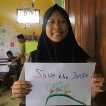 Student holding a 'Save the Jungle' Poster