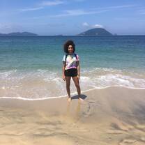 Grace standing in front of the ocean at Shikanoshima facing the camera with the wind blowing