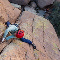 Student places protection while climbing