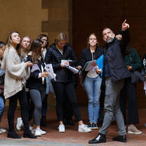 A professor points something out to a group of students