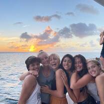 Group of teens on deck of boat at sunset
